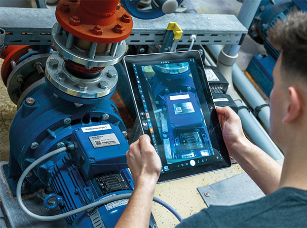 Picture shows a person holding a tablet over a device to see its individual parts enlarged on the display