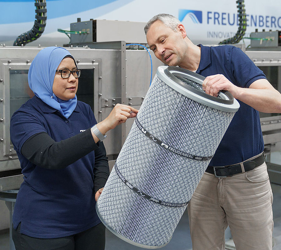 Picture of a woman and a man standing next to each other and holding a filter in their hands
